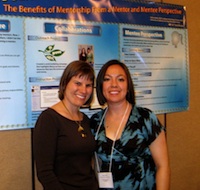 2 people presenting a poster on mentoring